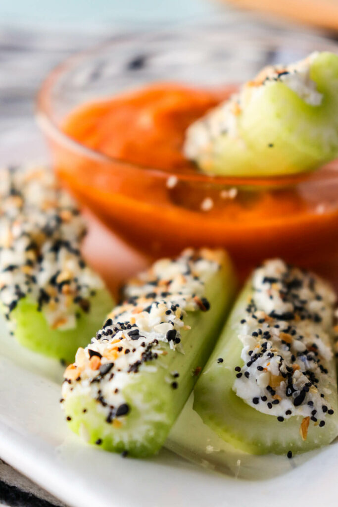 Easy keto celery snacks with keto Buffalo sauce for dipping on a white plate
