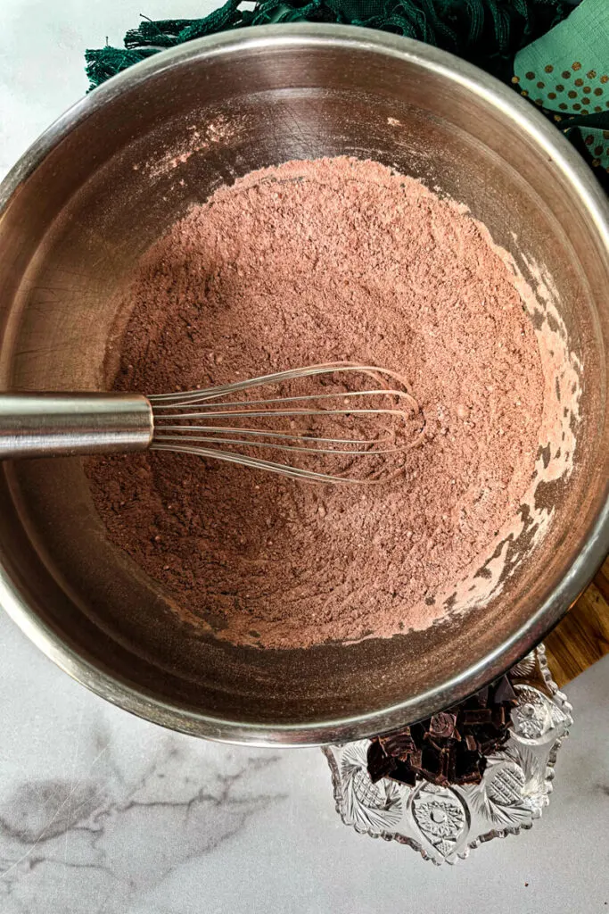 Overhead view of a bowl with a whisk and dry ingredients for keto brownies.