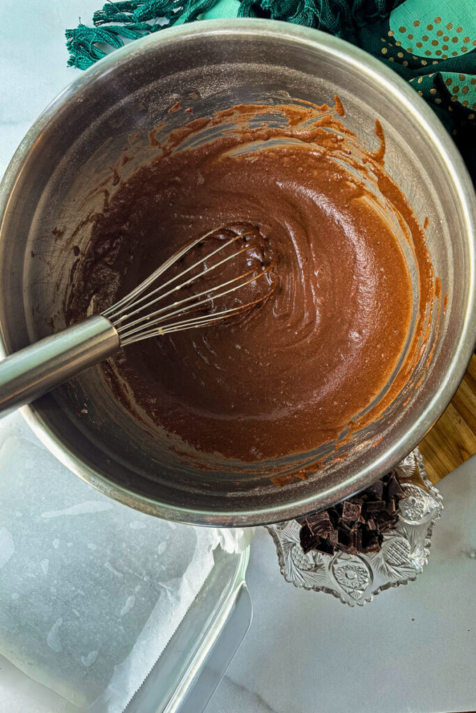 Overhead view of a metal containing a whisk and keto brownie batter