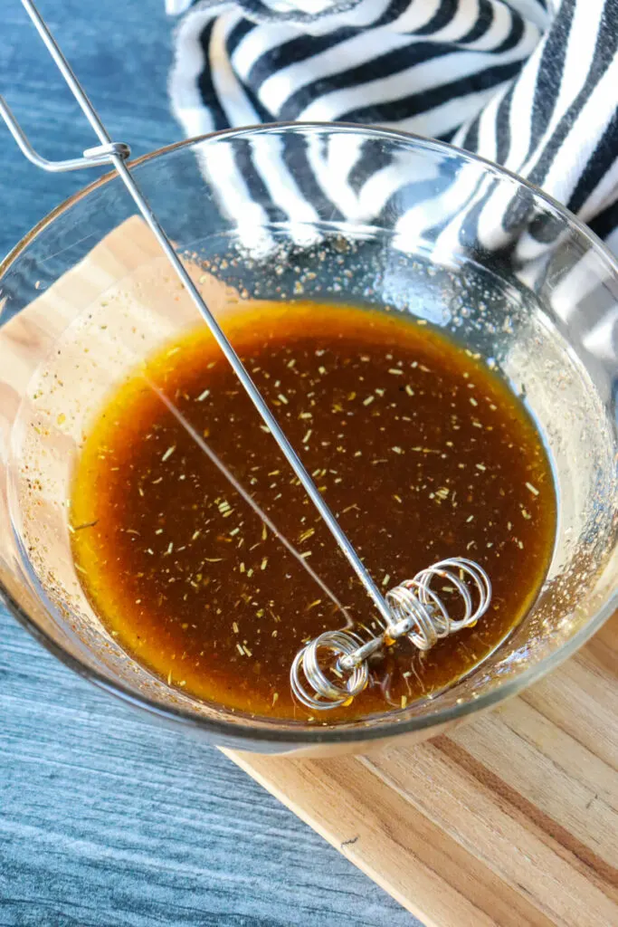 Whisk with a glass bowl of keto steak marinade