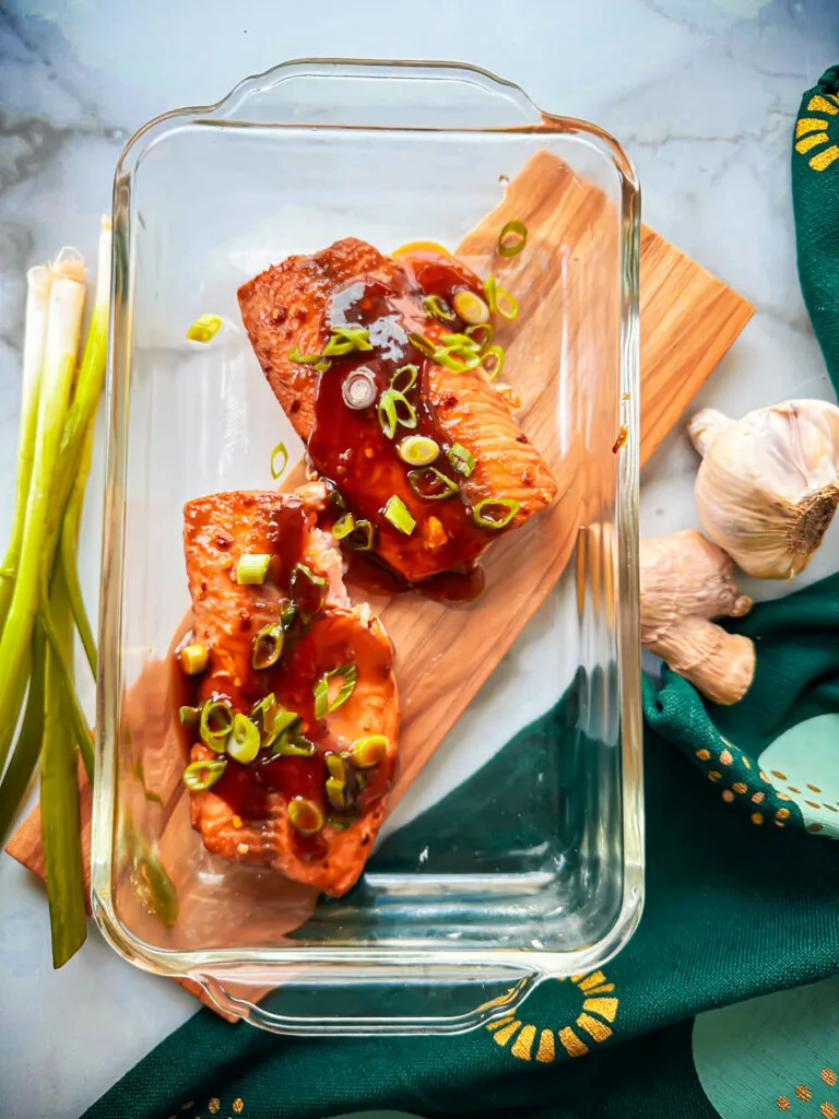 Overhead view of two servings of keto teriyaki salmon in a glass baking dish