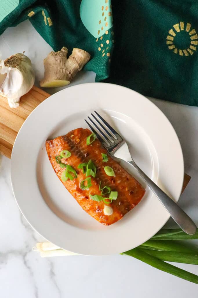 A serving of air fryer salmon teriyaki on a white plate