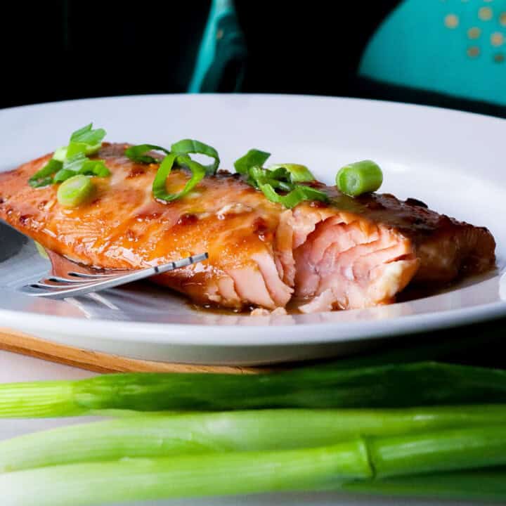 White plate with a bite out of a piece of air fryer teriyaki salmon