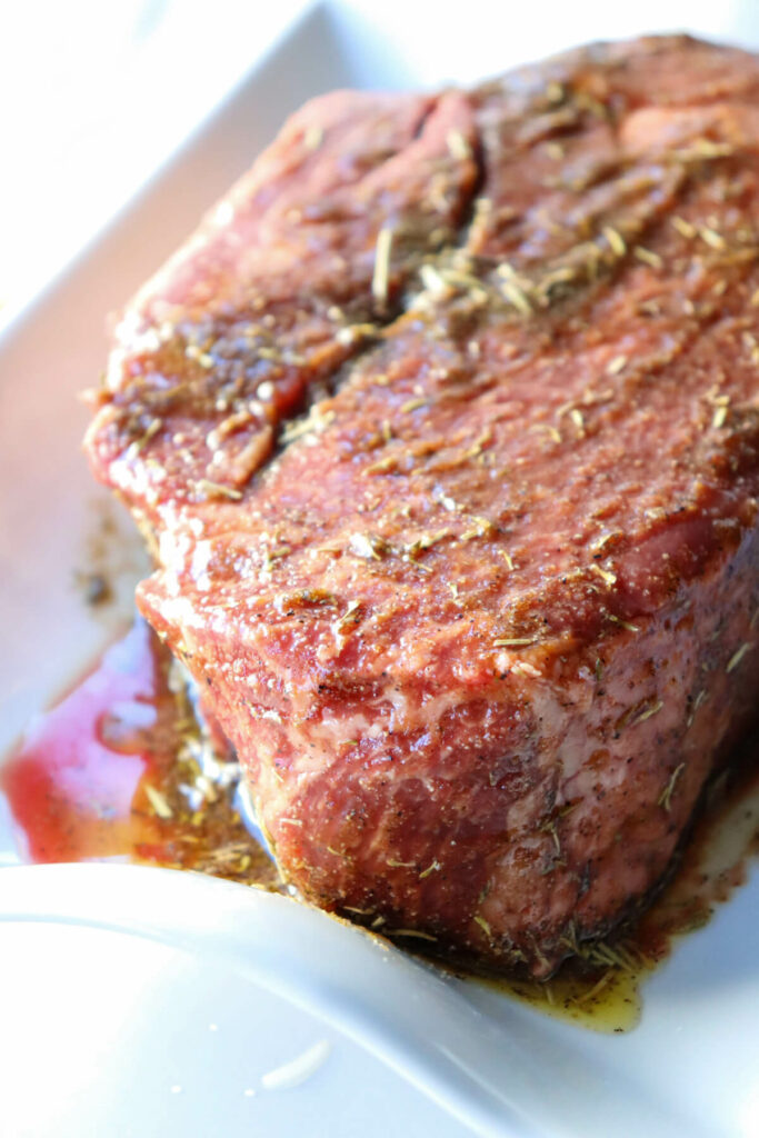 Front view of raw beef roast with the oil and spice rub