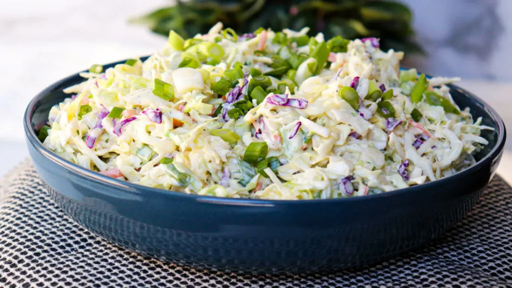 A front view of keto coleslaw in a blue bowl