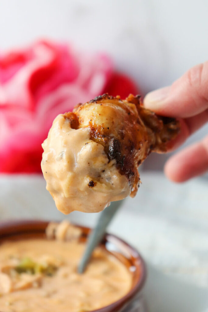Chicken wing dipped in queso