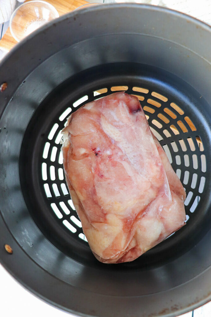 Overhead view of a frozen block of chicken wings in the air fryer basket