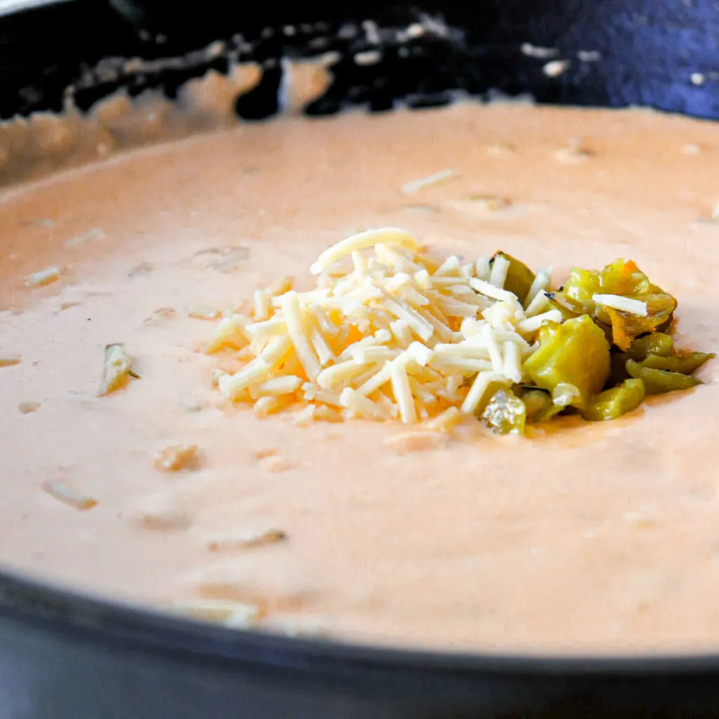Close up view of green chile queso in a cast iron skillet
