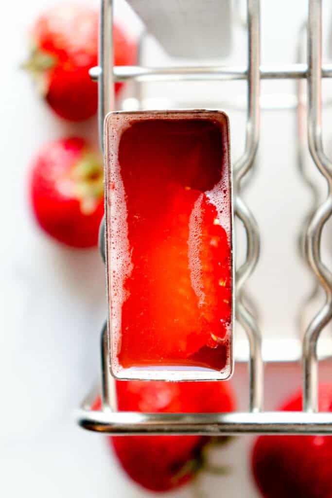 Overhead view of one stainless steel popsicle mold with sugar free popsicle mixture