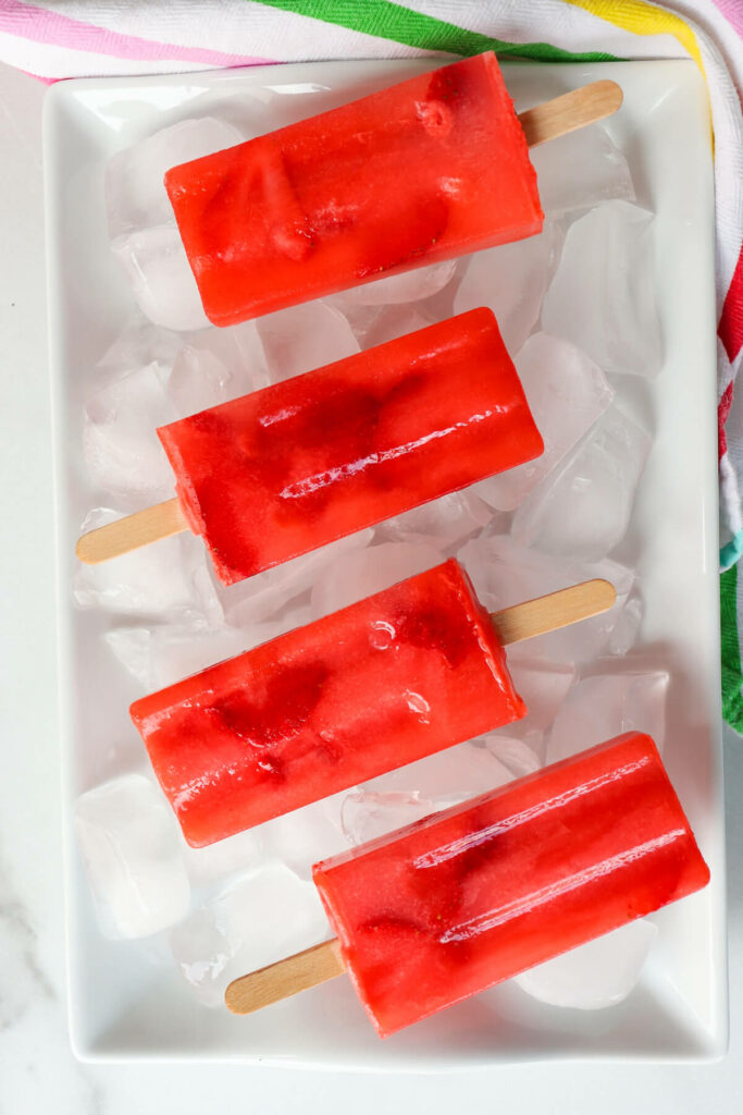 Overhead view of red sugar free popsicles, keto strawberry lemonade on ice