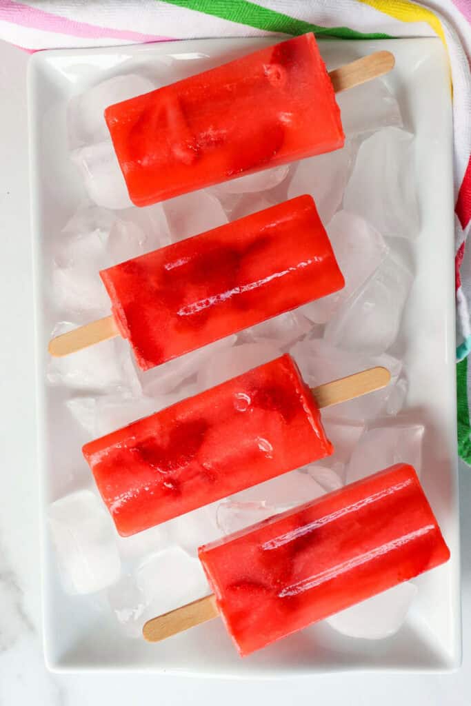 Overhead view of red sugar free popsicles, keto strawberry lemonade on ice