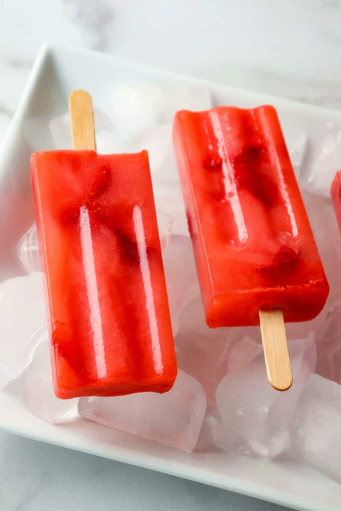 Overhead view of red sugar free popsicles, keto strawberry lemonade on ice