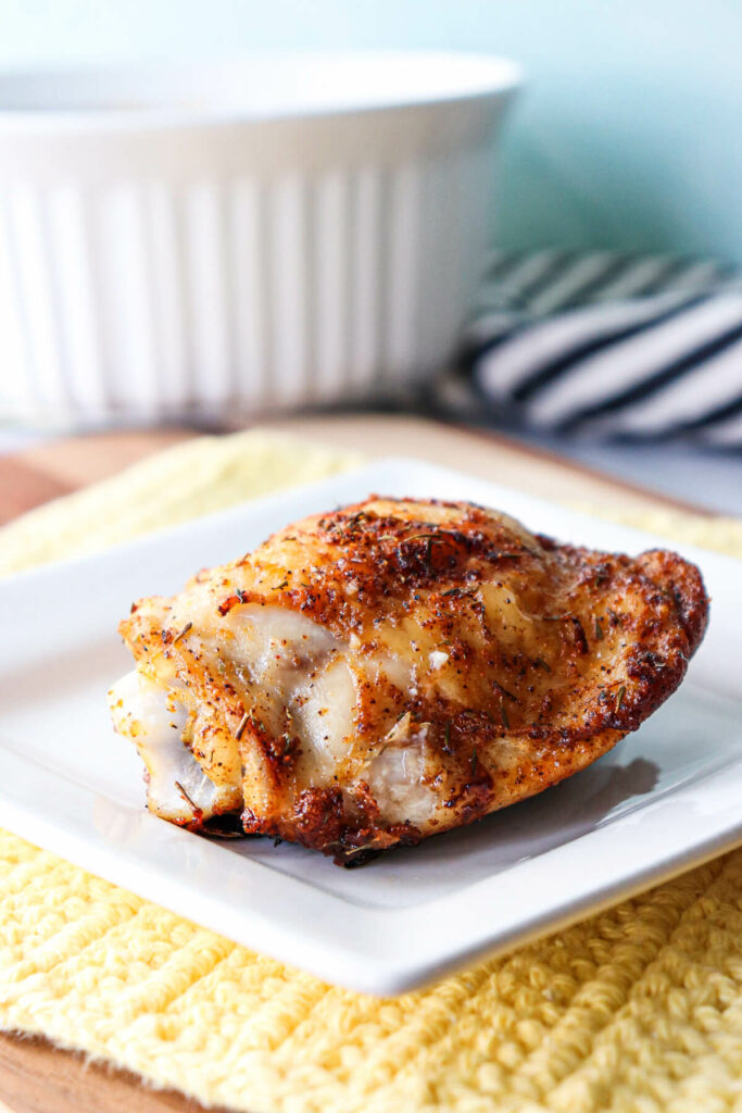 Front view of view of a keto baked chicken thigh on a white plate