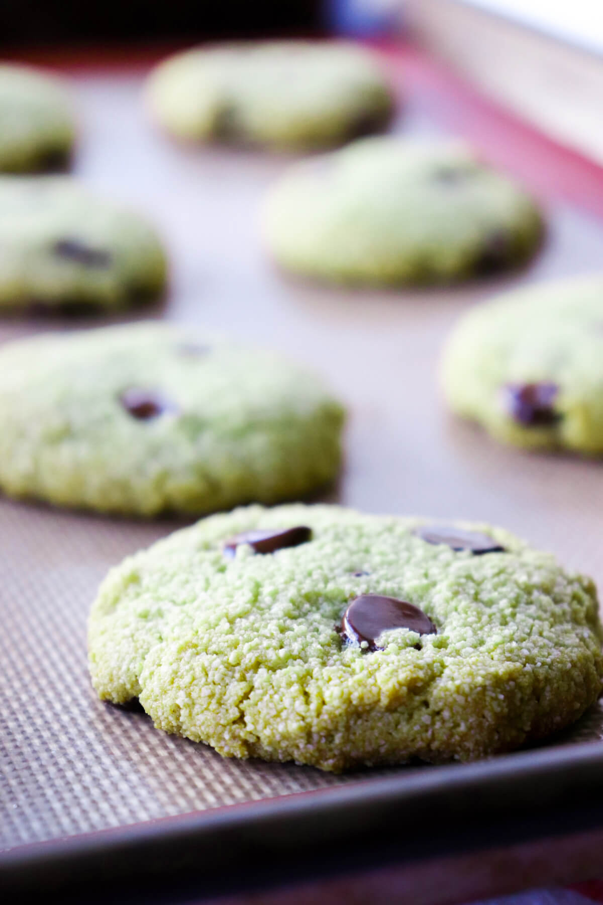 Front closeup view of gluten free matcha cookies on a silicone liner in a pan