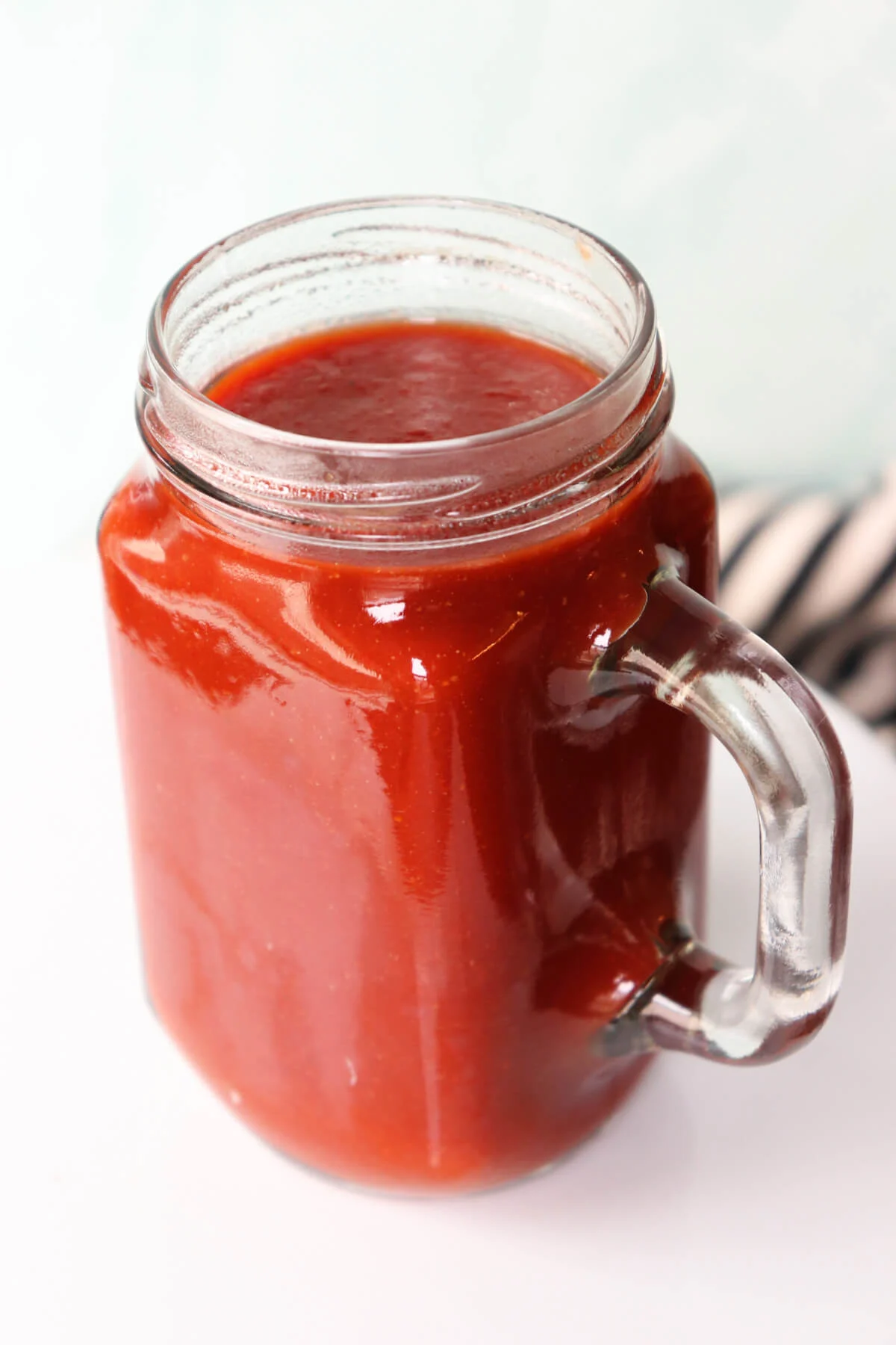 Jar of keto BBQ sauce on a white plate
