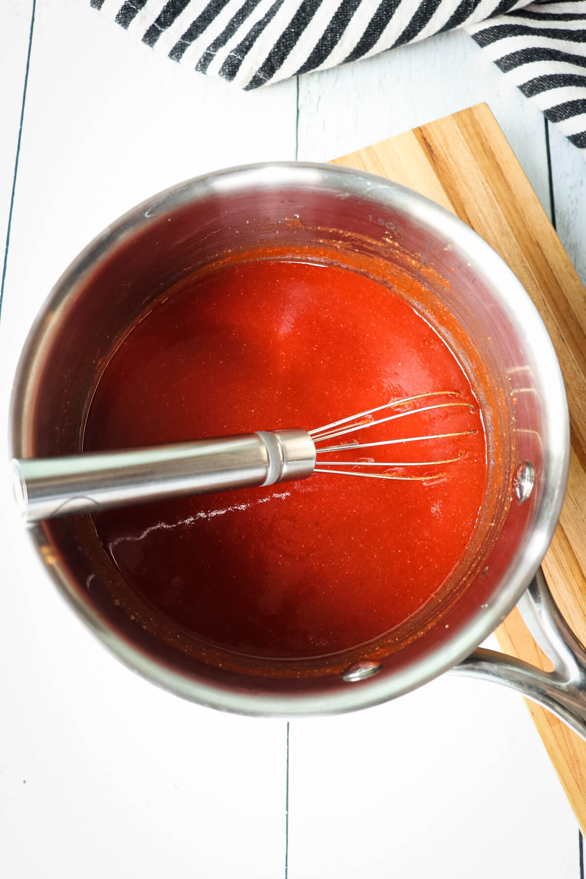 Overhead view of saucepan with keto ketchup and whisk