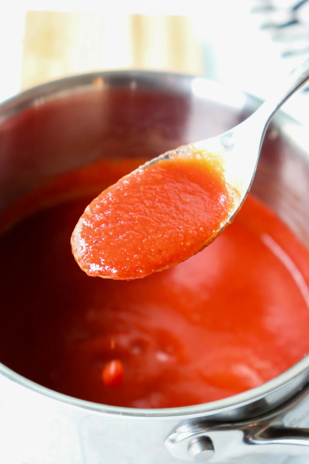 Spoon of sugar free ketchup over a saucepan