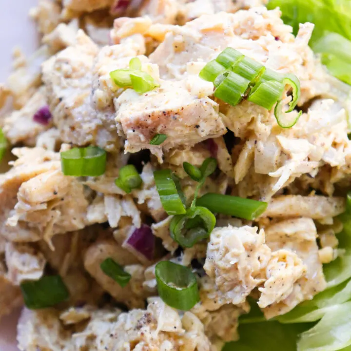 Overhead closeup view of curry keto chicken salad with sliced green onions