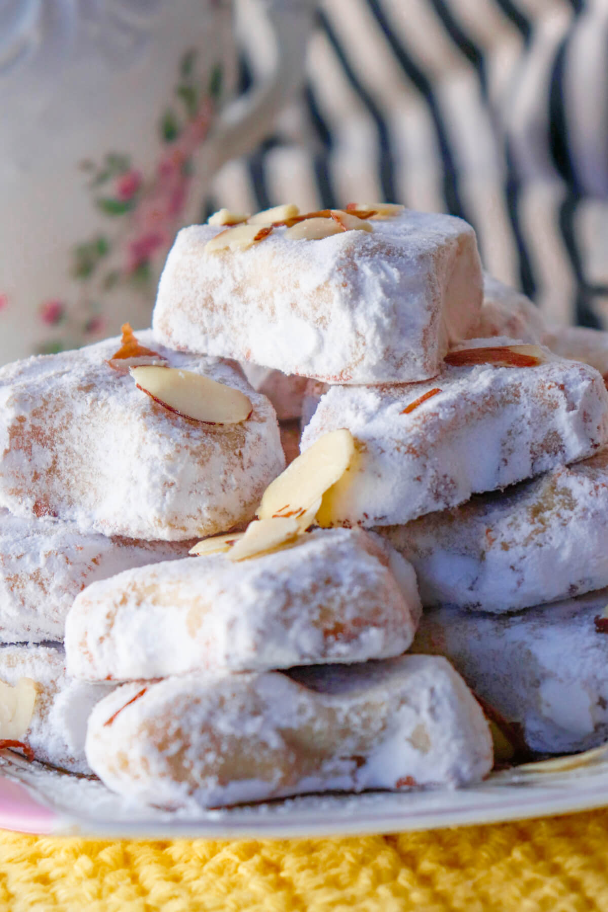 Traditional Greek Almond Cookies in a stack on a white and pink plate