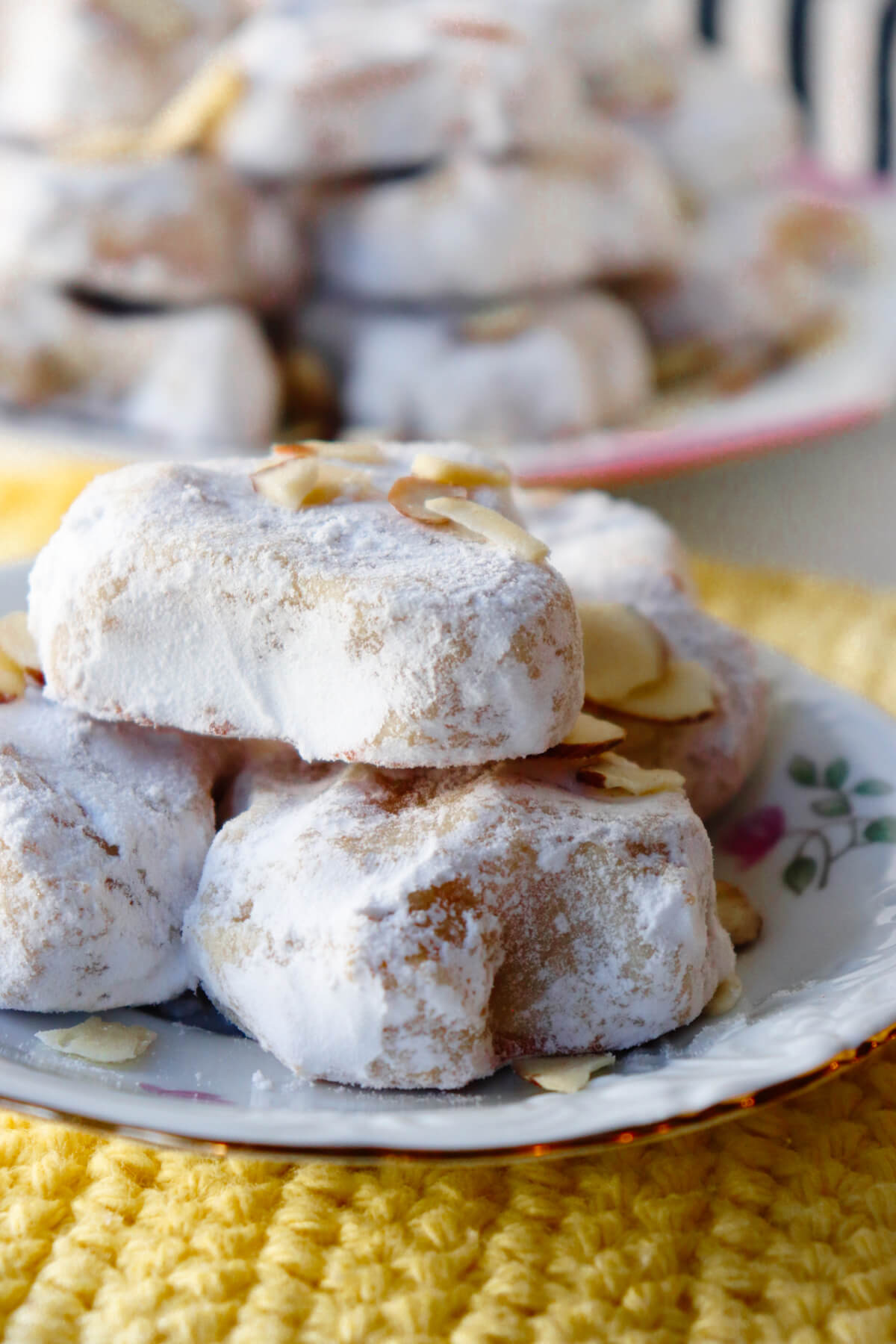 Traditional Greek Almond Cookies in a stack on a white and pink plate