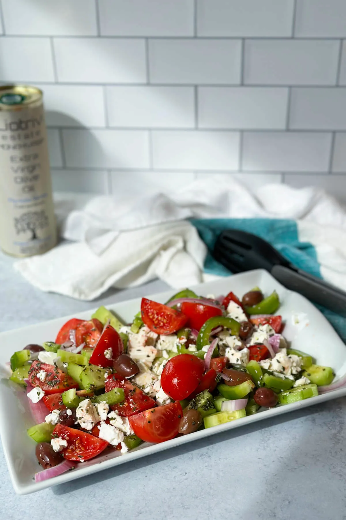 Plate of Greek cucumber and tomato salad on a white plat with crumbled feta cheese