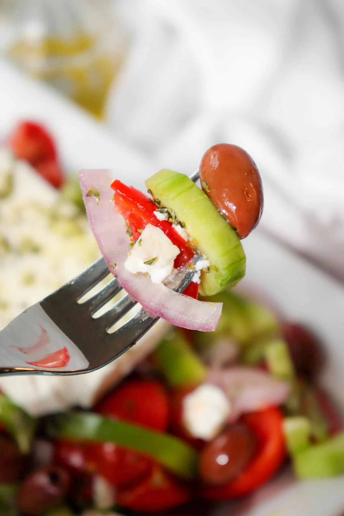 Bite of Greek cucumber and tomato salad on a fork