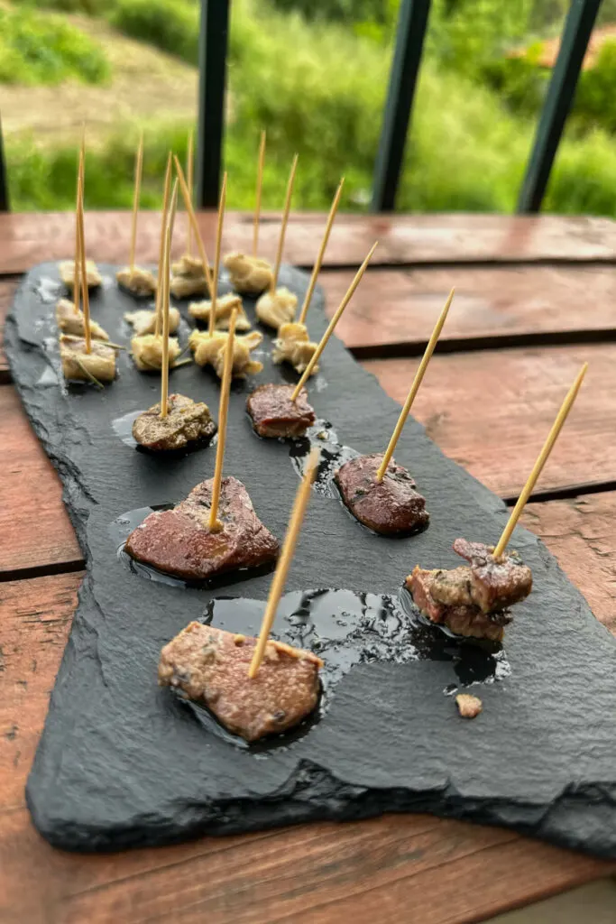 Black stone plate of fish samples with toothpicks