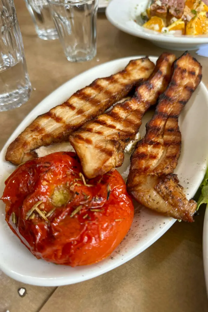 Plate of pork and a stewed tomato