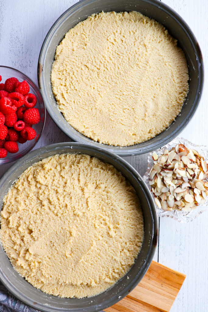 Overhead view of two cake pans with keto yellow cake batter in them