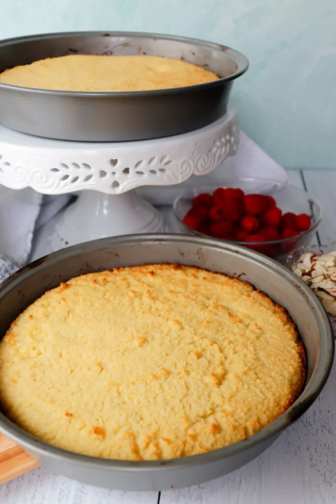 Two cake pans with baked keto yellow cakes in them