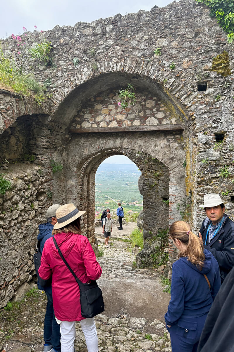 A local guide with a group looking at one of the gates of Mystras to block out invaders