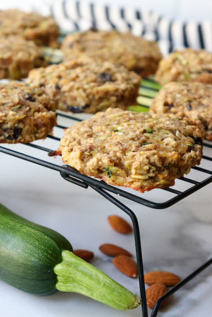 Keto breakfast cookies cooling on a black metal cooking rack over a zucchini