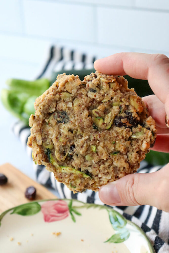 A hand holding up a keto zucchini breakfast cookie