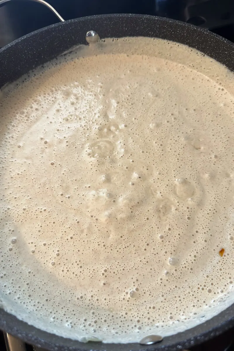 Overhead view of satsivi sauce in a skillet.