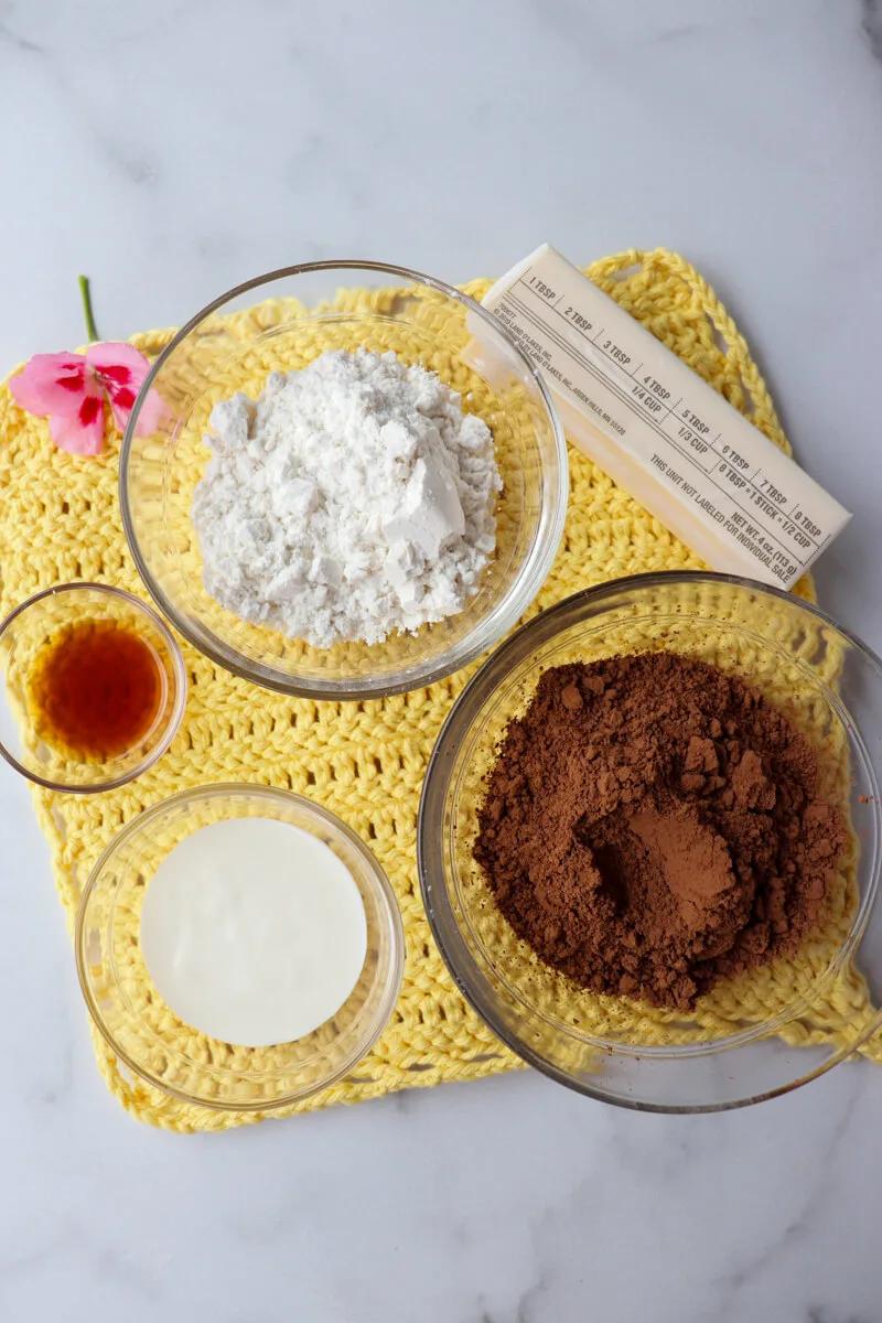 Overhead view of glass bowls of keto zucchini brownie ingredients.