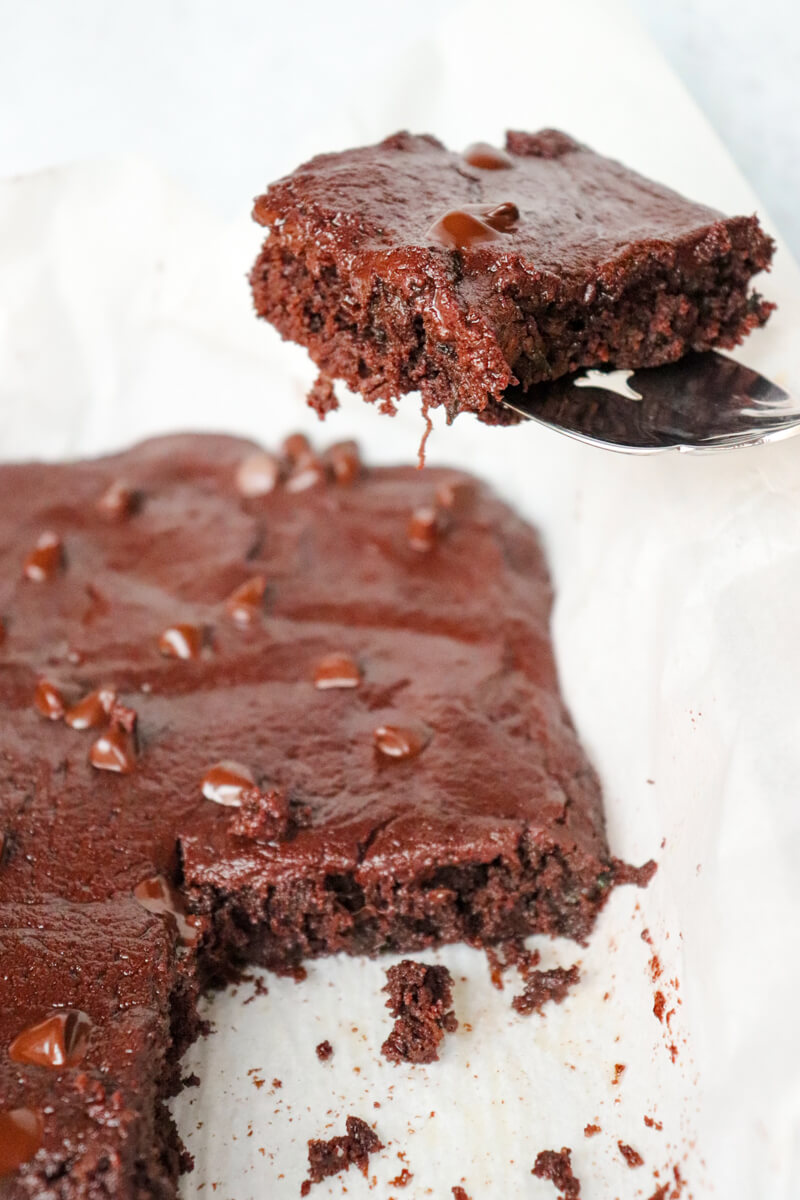 A spatula removing a keto zucchini brownie from the pan.