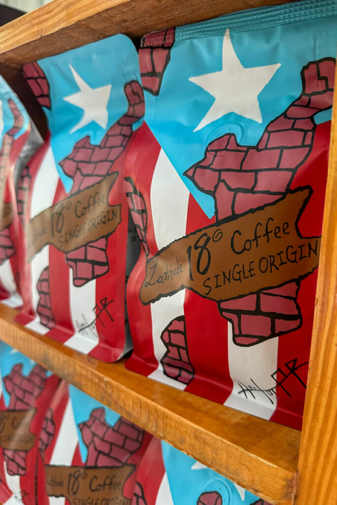 Shelves filled with red, white, blue, and brown bags of Latitude 18 coffee