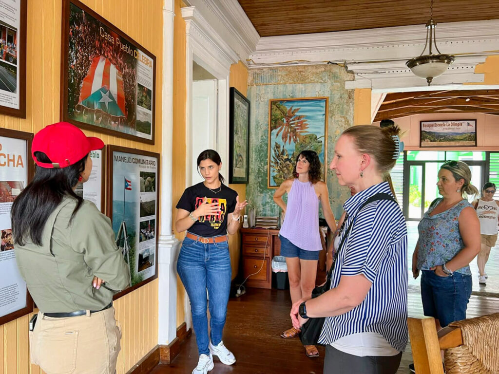 Visitors listening to a guide speak about Casa Pueblo