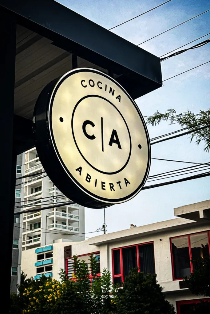 Outside white circle sign for Cocina Abierta