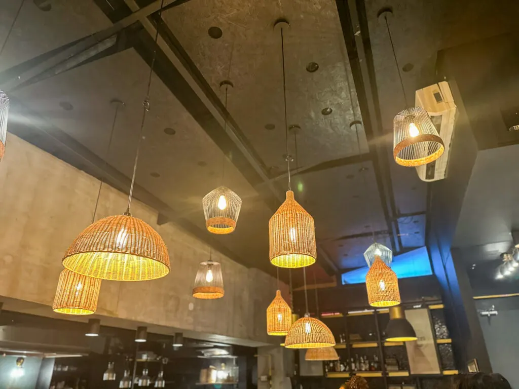 Fun lamps in different shapes hanging from a high ceiling