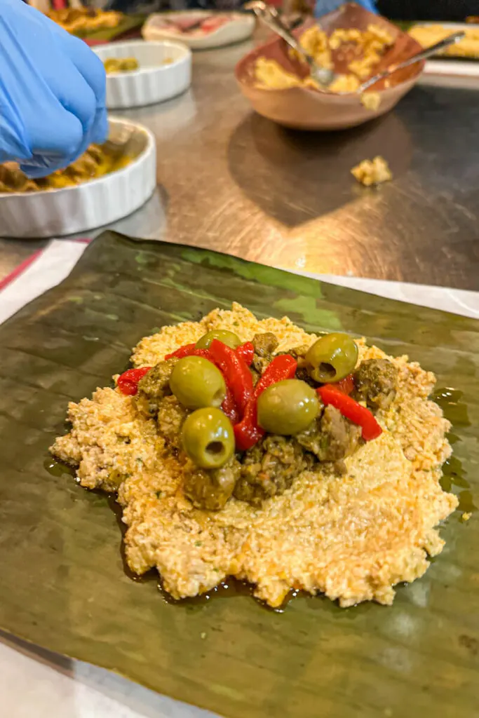 Pasteles being made with olives, red peppers, and pork