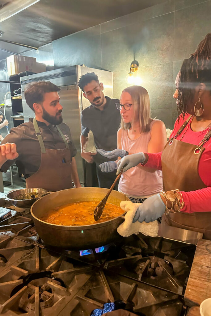 Three people waiting expectantly to see if the blond woman approves of the taste