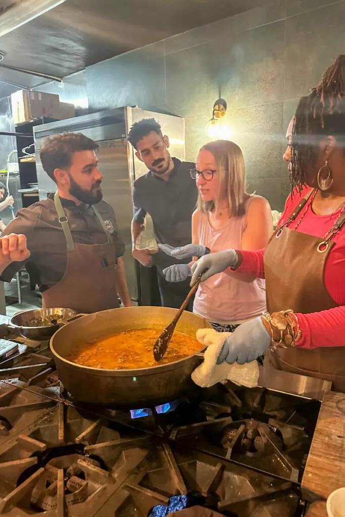 Three people waiting expectantly to see if the blond woman approves of the taste