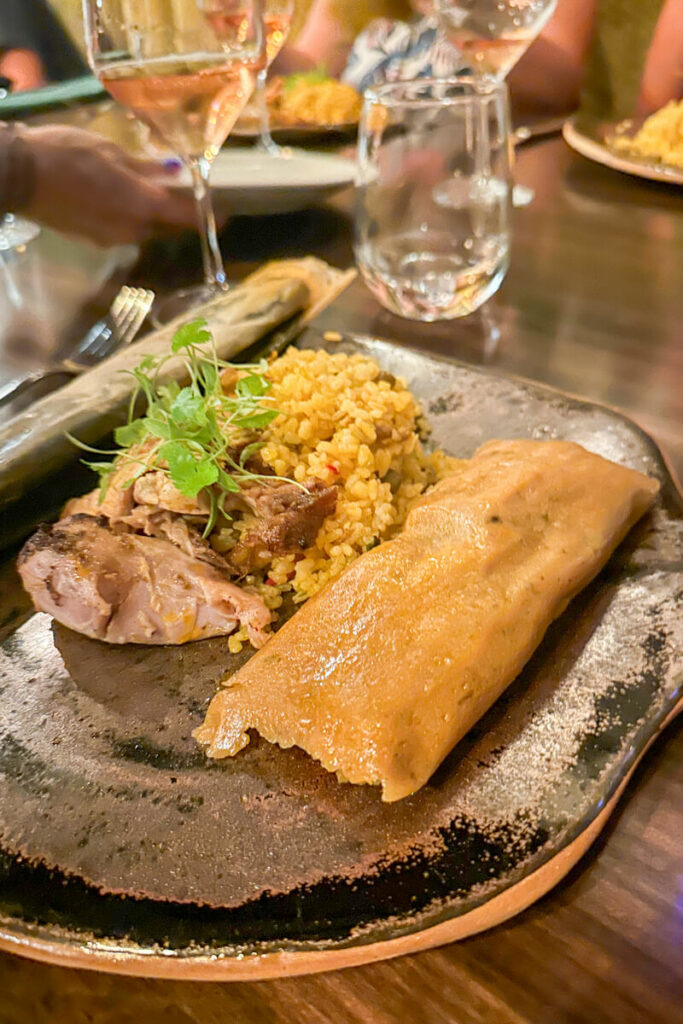 A plate of Puerto Rican authentic food, pork, rice, and pasteles.