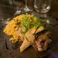 A plate of Puerto Rican authentic food, pork, rice, and pasteles.