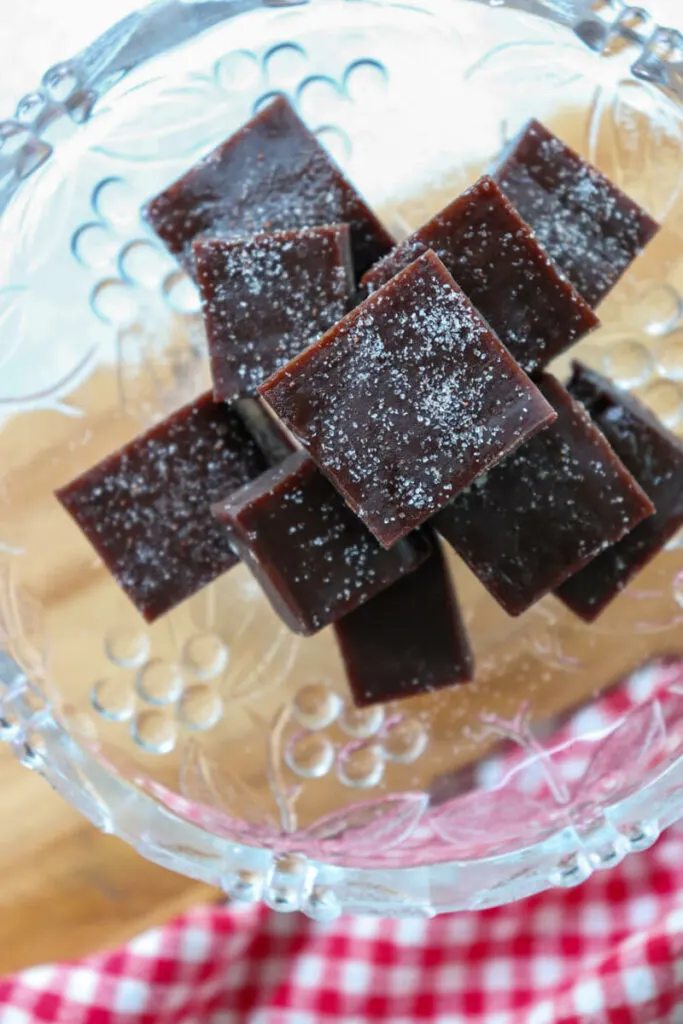 Overhead view of a stack of low carb fudge on a wooden plank next to a red and white towel