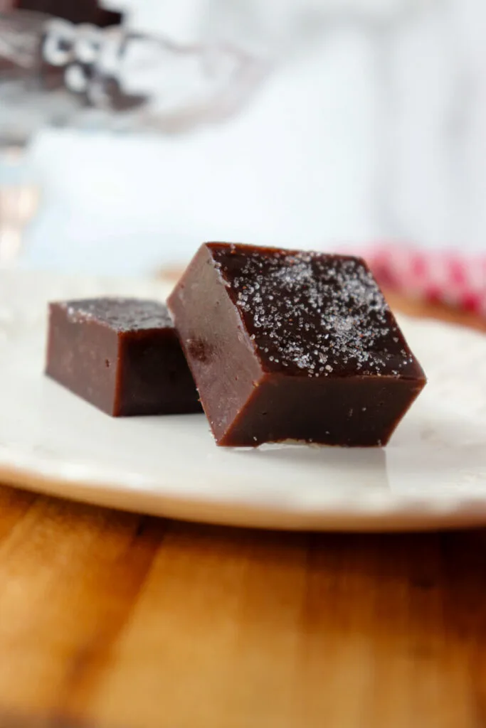 A white plate with 2 pieces of keto fudge on top or a wooden platter