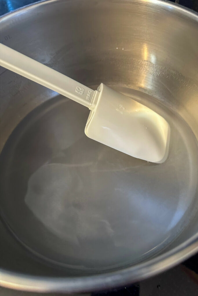 Overhead view of a white rubber spatula and saucepan