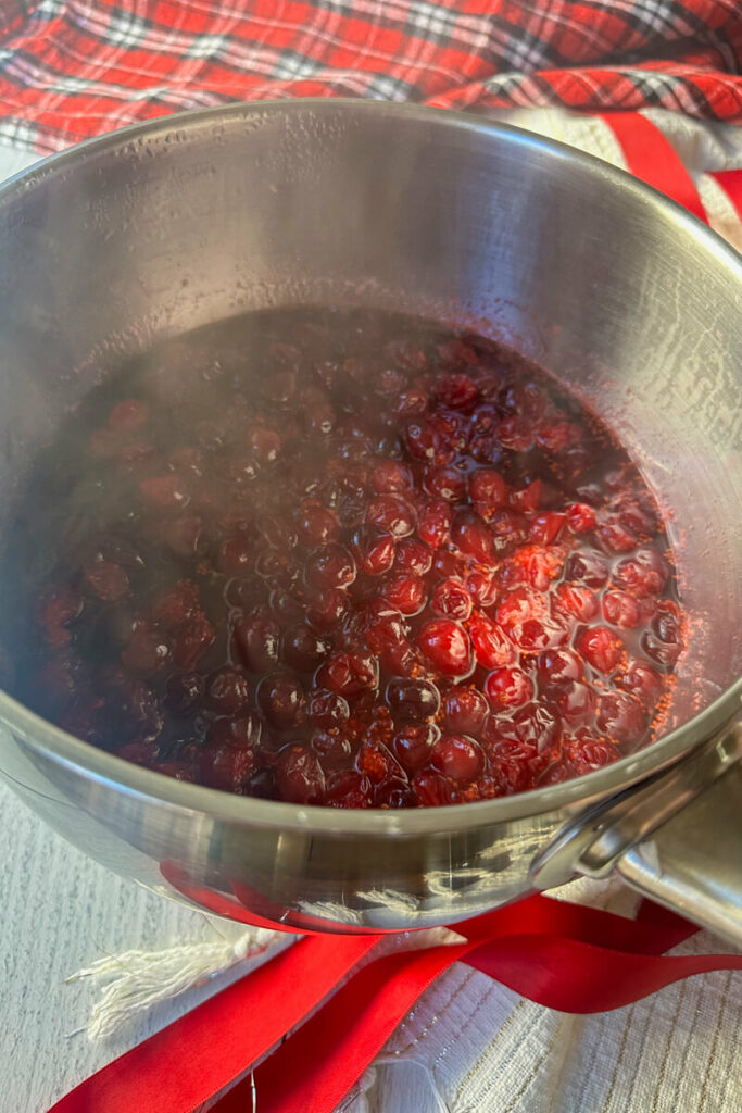 Overhead view of boiling cranberries in a metal saucepan