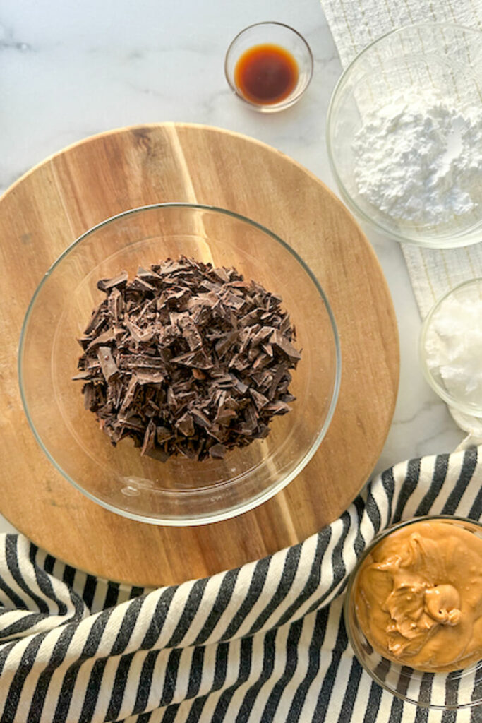 Overhead view of a glass bowl of chopped chocolate